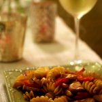 Kung Pao Pasta Plate of kung pao pasta with a glass of wine.