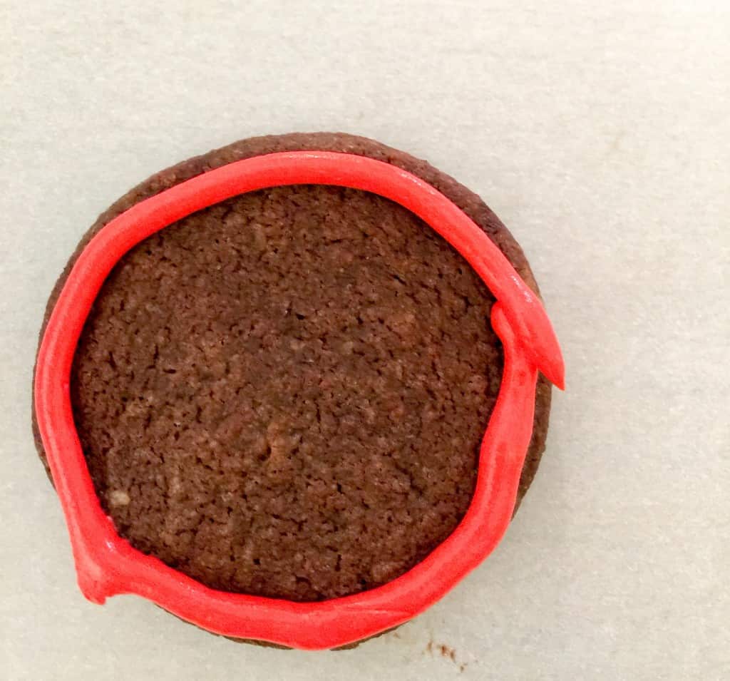 dark chocolate shortbread cookie with a piped red circle
