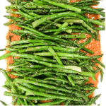 platter of asparagus on top of romesco sauce