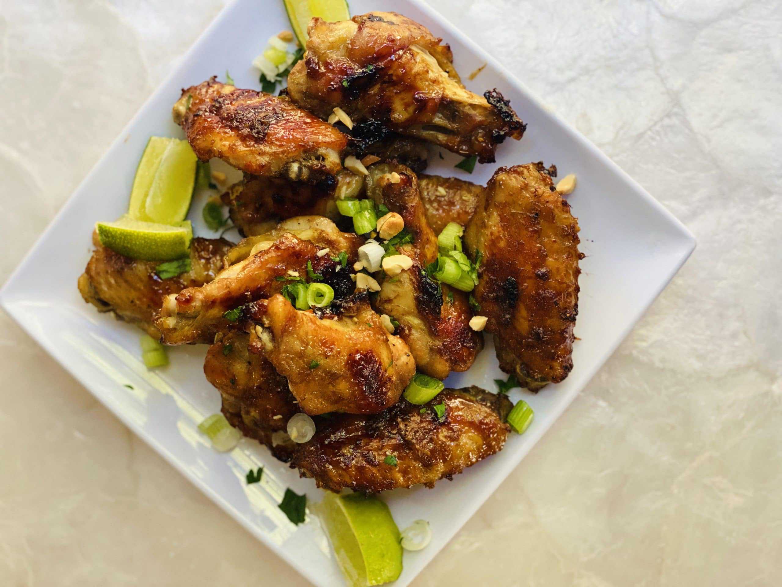 white plate with baked sweet and spicy chicken wings.