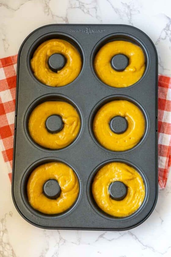 Mini donut pan filled with pumpkin spice batter.