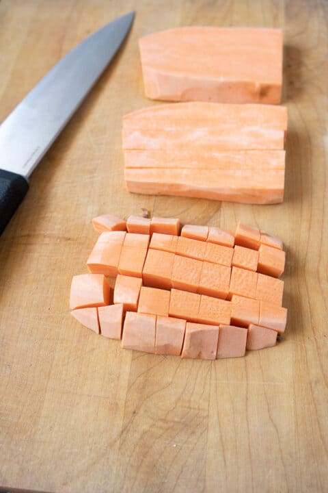 Diced Sweet potatoes on a cutting board.